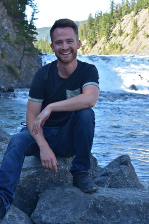 Zane, sitting on the bank of Bow Falls in Alberta